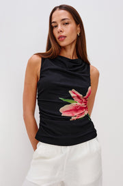 woman wearing a black sleeveless top with a pink lily design on the side
