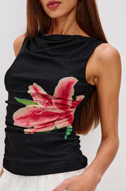 Close-up a black sleeveless top with a pink lily design on the side