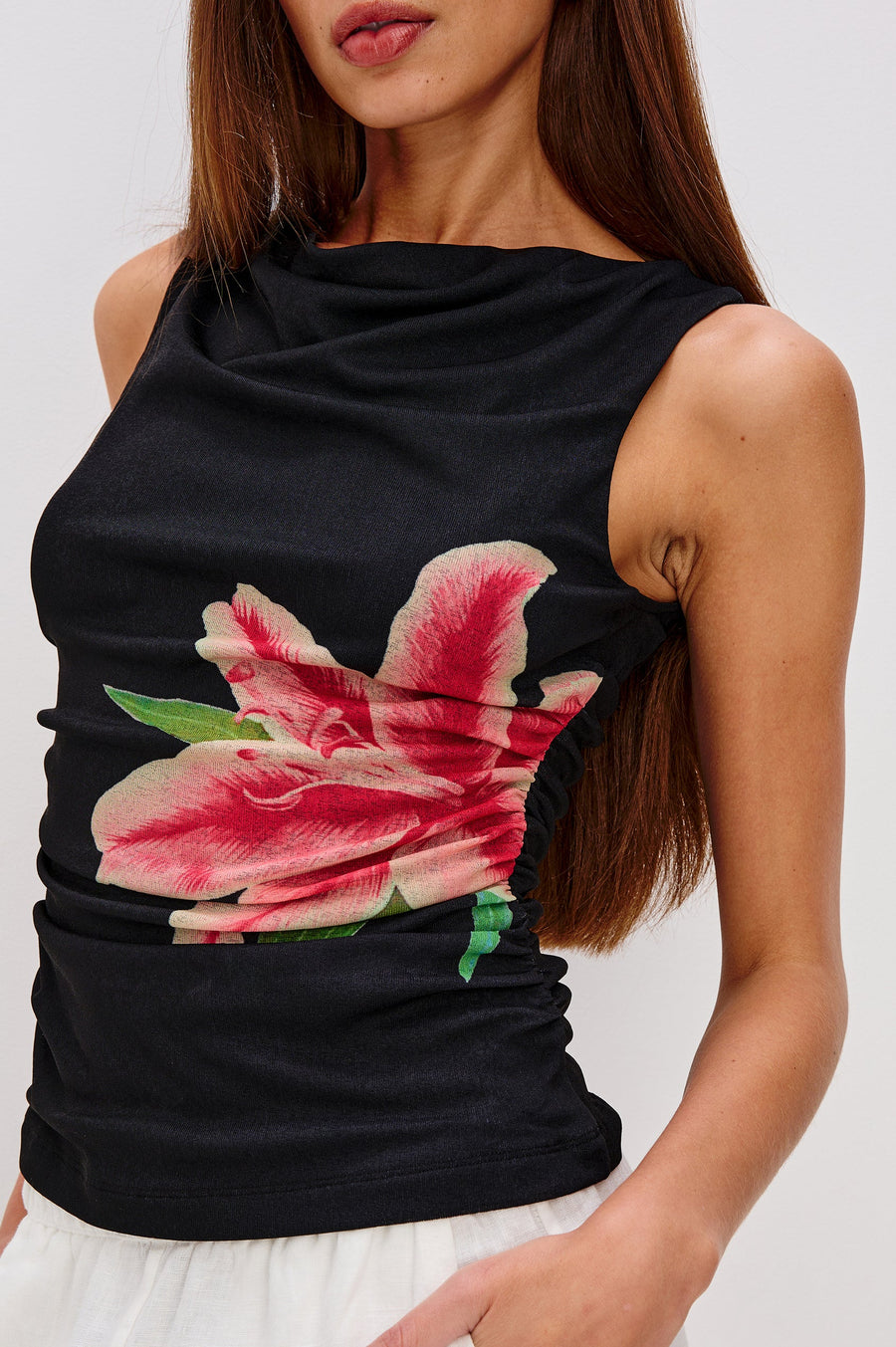 Close-up a black sleeveless top with a pink lily design on the side