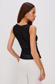 woman wearing a black sleeveless top with a pink lily design on the side