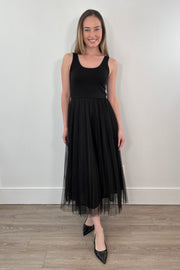 woman waring black sleeveless dress with a tulle skirt