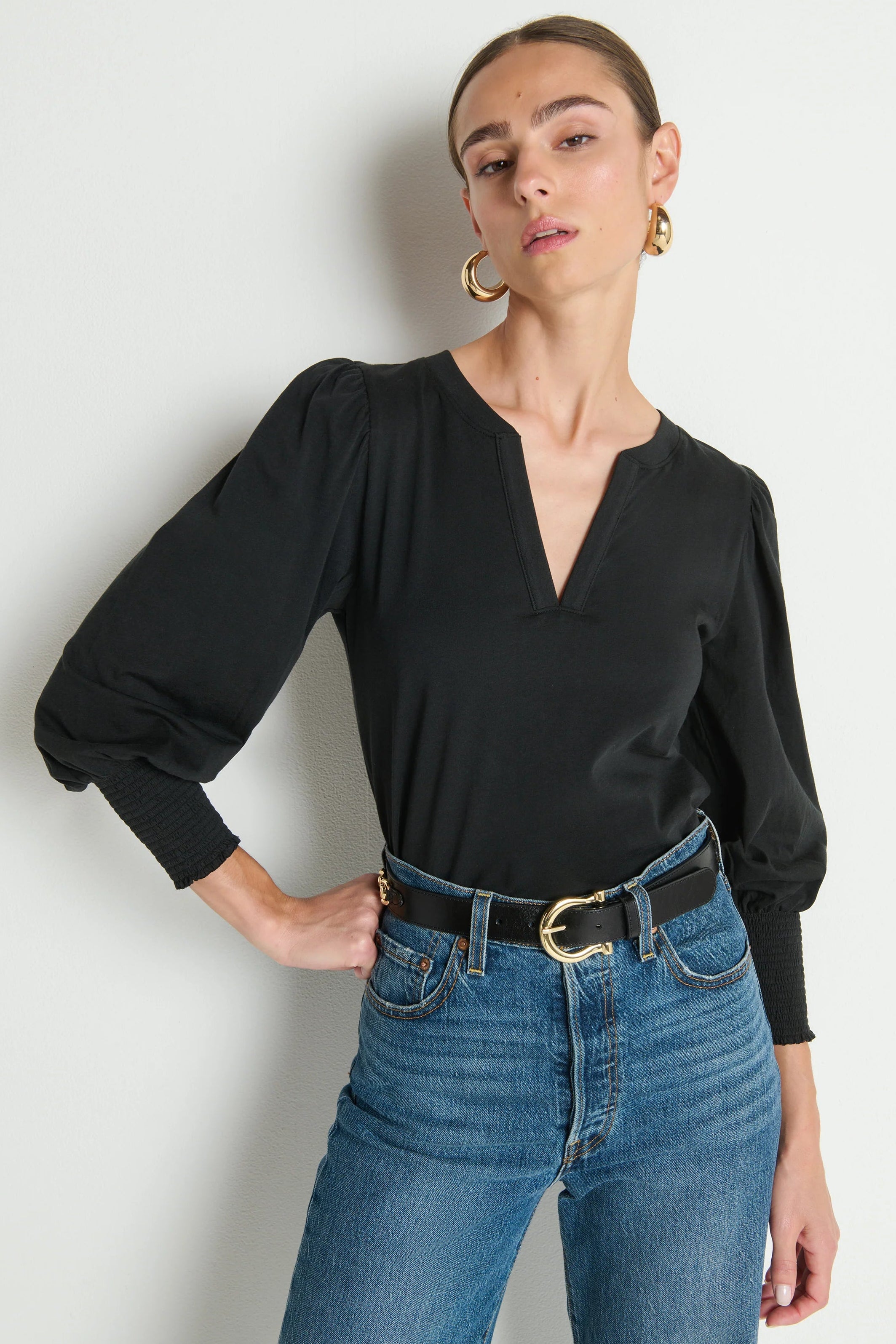 woman wearing a black v-neck top with puffed and cuffed 3/4 sleeves