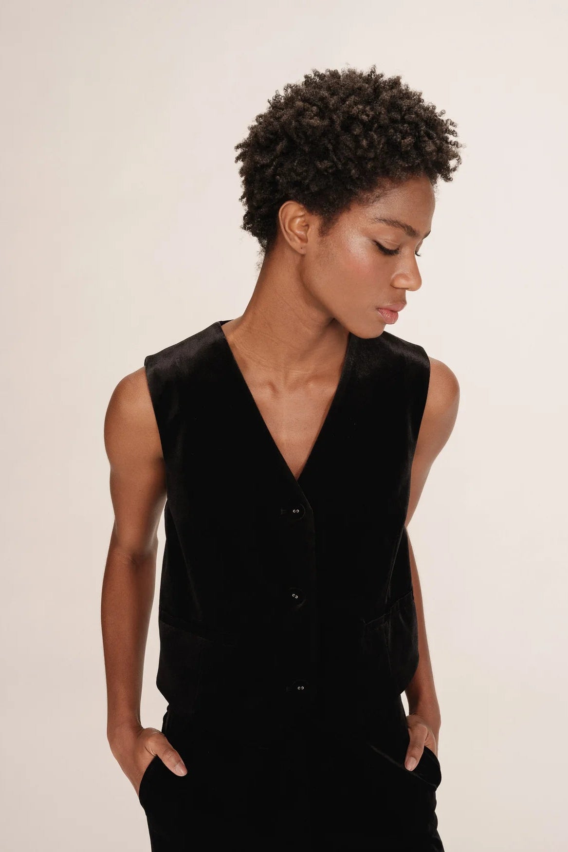 Person wearing a black vest against a plain background