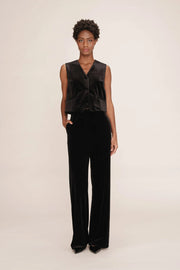 Person wearing a black velvet outfit on a plain background