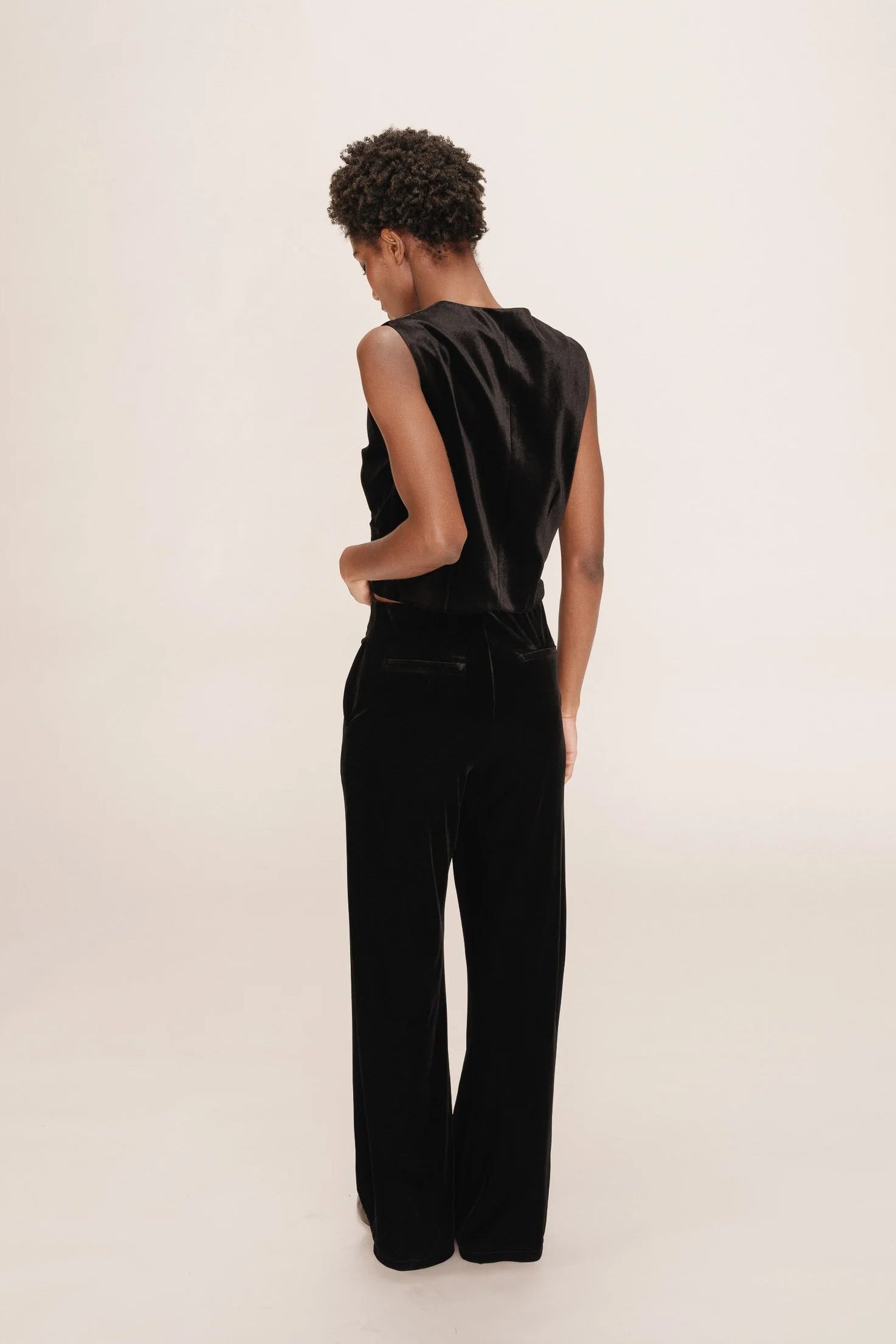 woman wearing matching black velvet vest and pants