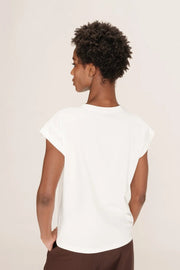 Person wearing a white top and brown pants on a plain background