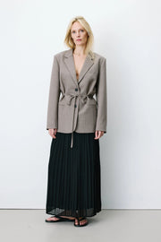 Woman wearing a gray blazer with a belt