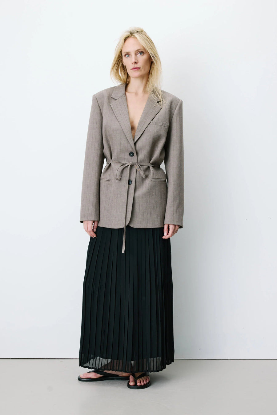 Woman wearing a gray blazer with a belt