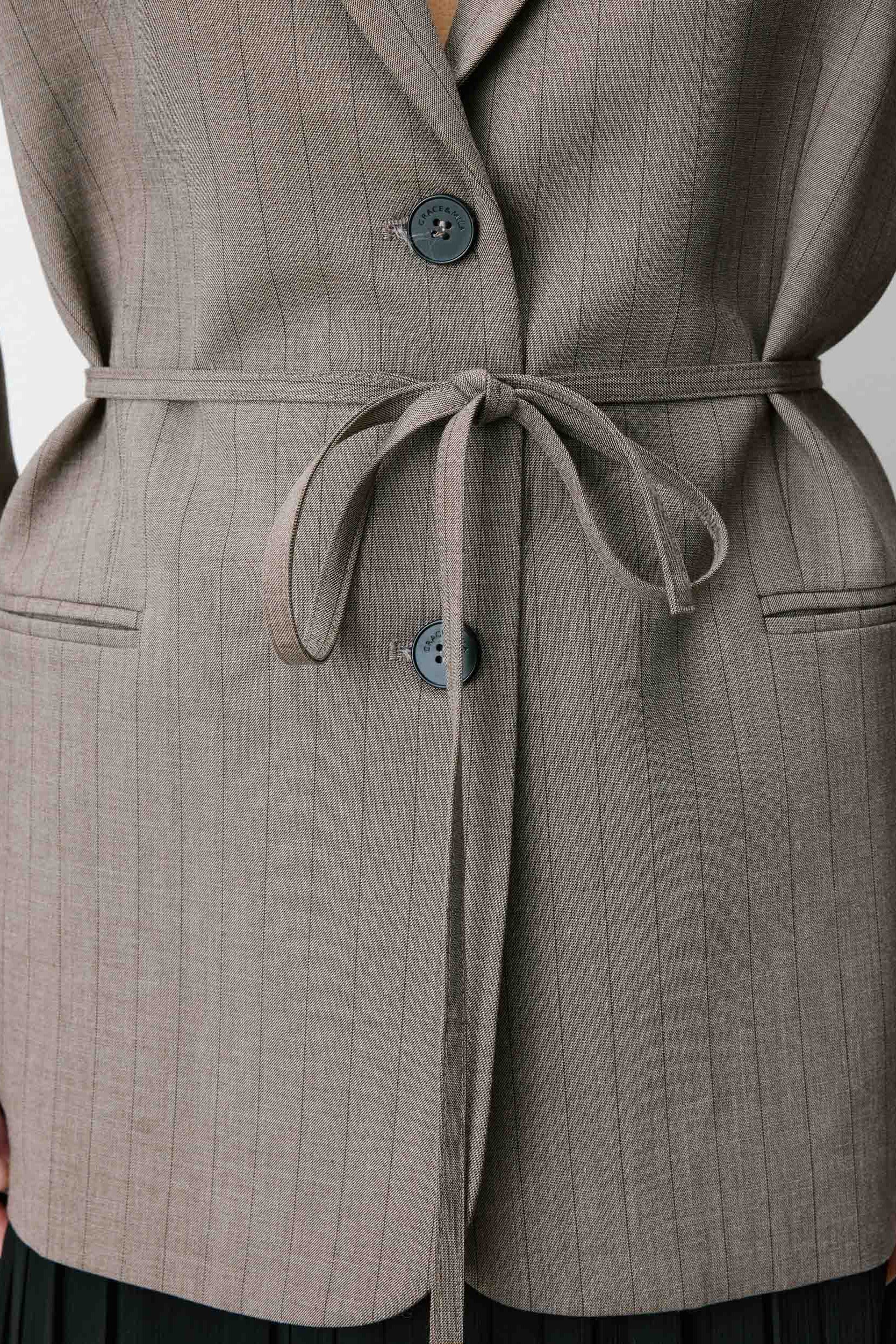 Woman wearing a gray blazer with a belt