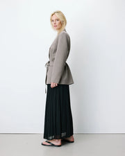 Woman wearing a gray blazer with a belt