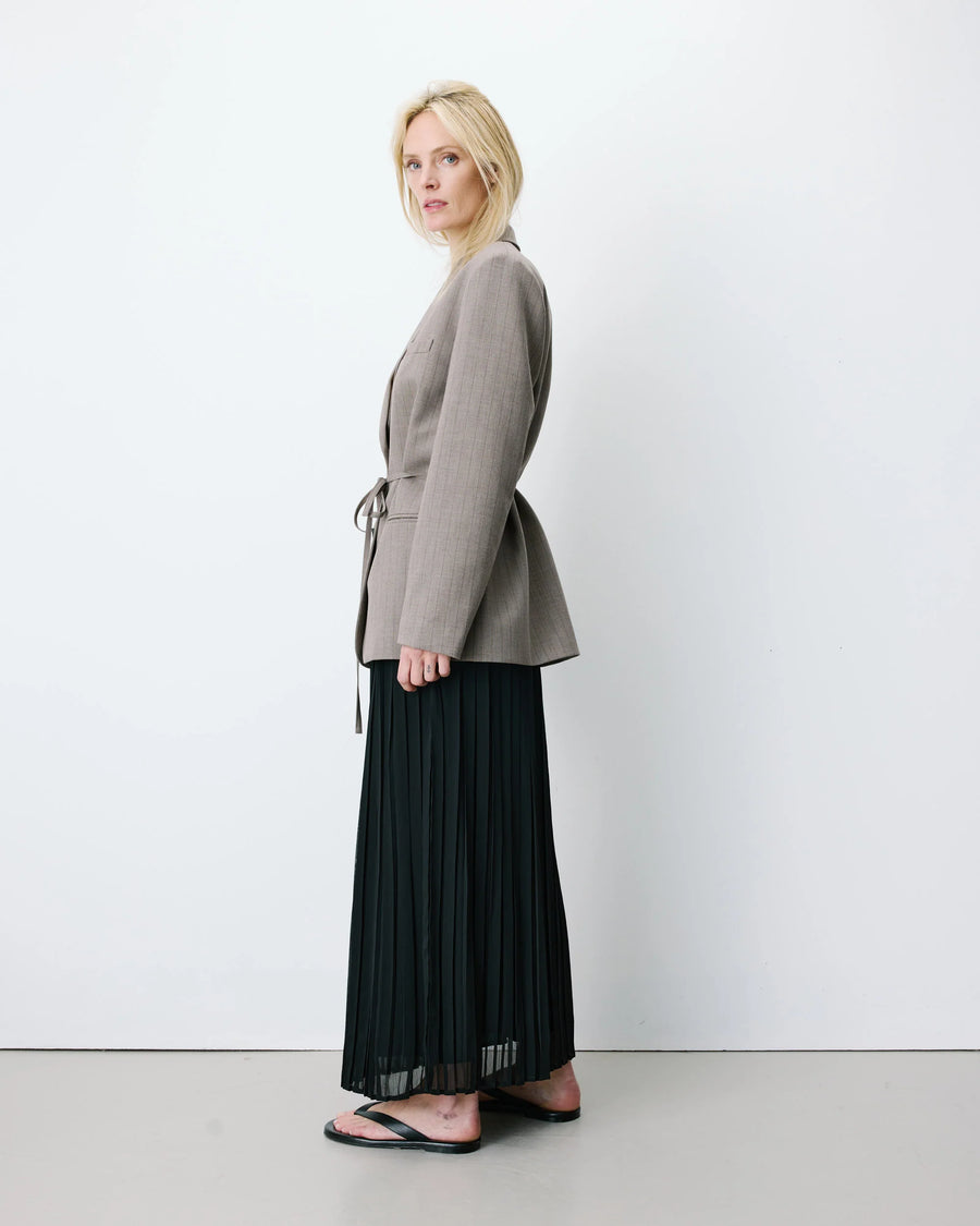 Woman wearing a gray blazer with a belt