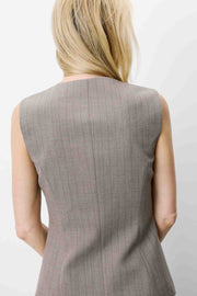 Woman wearing a sleeveless gray vest with buttons