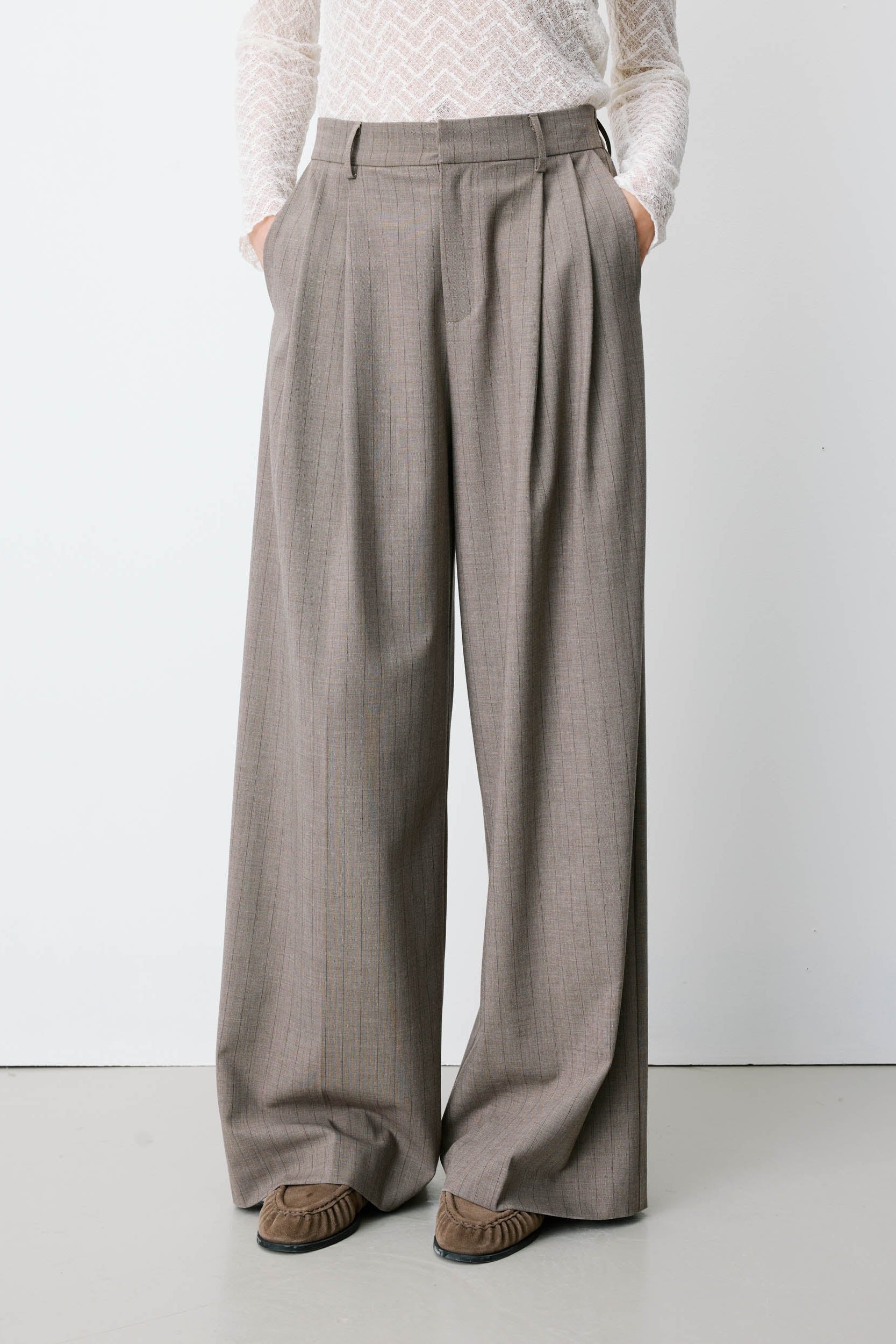 women wearing wide leg grey trousers. 