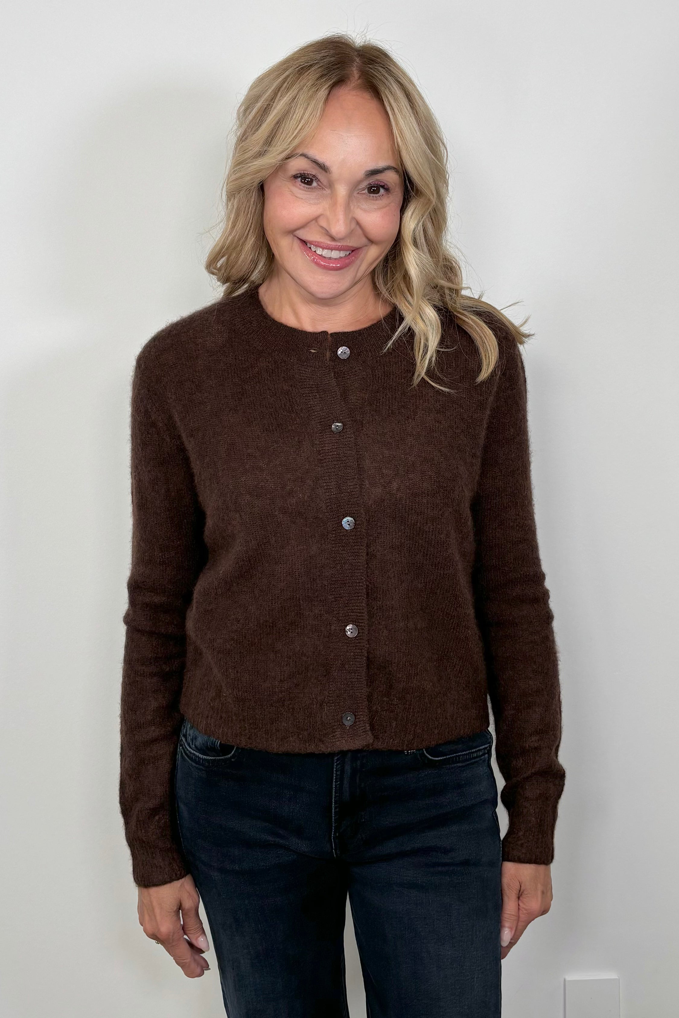 Front facing woman wearing a brown cashmere and silk blend cardigan closed.