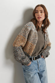 woman wearing a light gray, beige and dark gray knitted cardigan