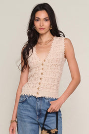 Woman wearing a light beige knit vest with button up detail