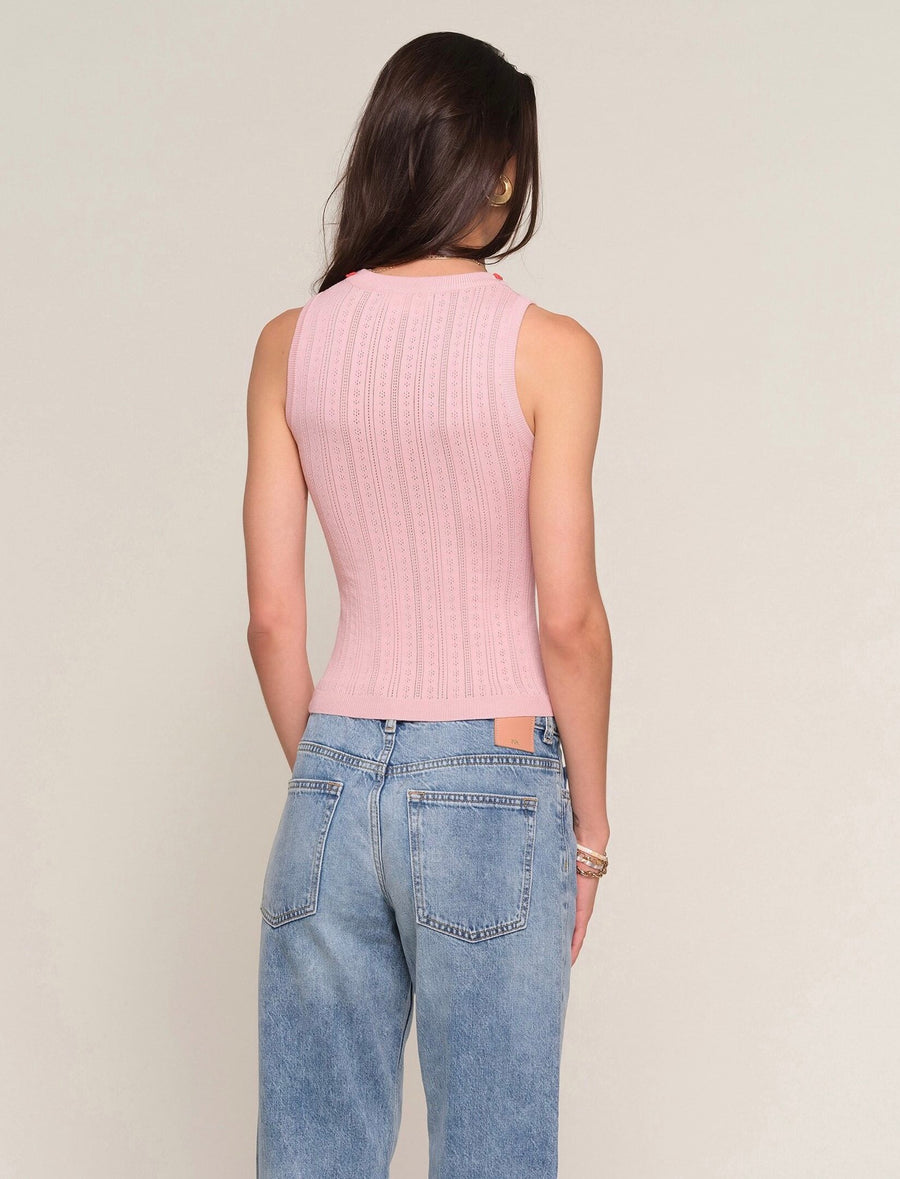 Back view of Woman wearing a ballet pink knit tank top with embroidered floral print around the neckline