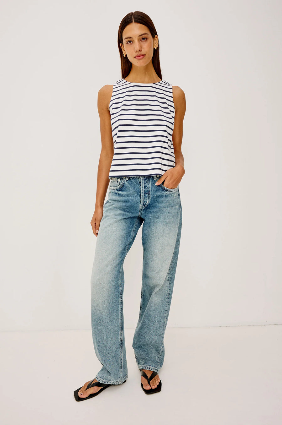 Woman wearing a blue and white striped tank top with a scoop neckline 