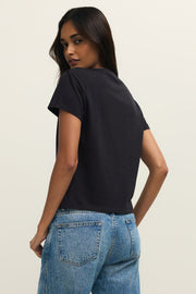 Woman wearing wearing a black crewneck t-shirt with the word "LOVE" written on the front in white lettering, back view