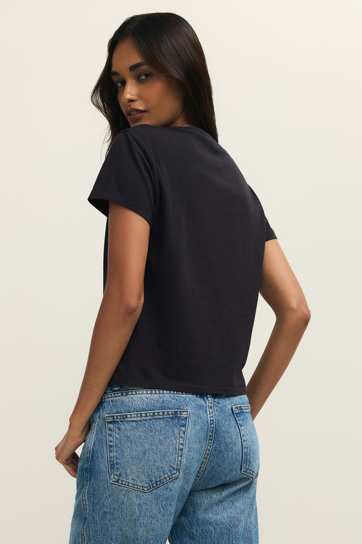 Woman wearing wearing a black crewneck t-shirt with the word "LOVE" written on the front in white lettering, back view