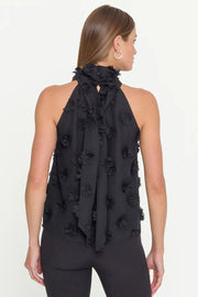 woman wearing  a halterneck black top with 3D fabric flowers all over