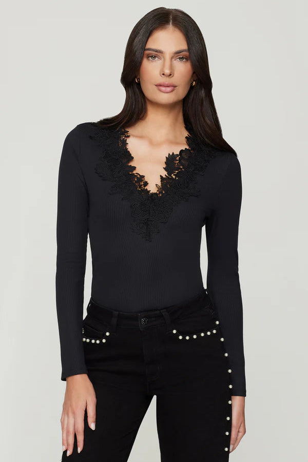 Woman wearing a black long-sleeve top with lace details in the v-neck
