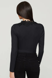 woman wearing a black long-sleeve top with lace details in the v-neck