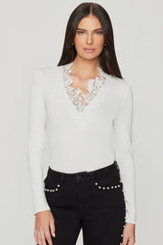 Woman wearing a white blouse with lace details and black pants