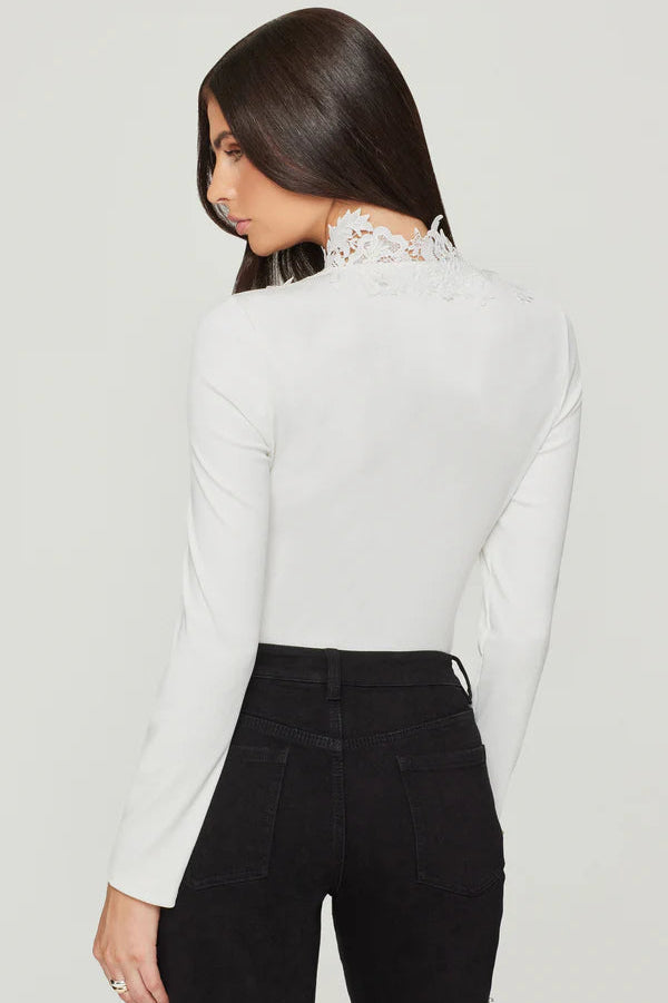 Woman wearing a white blouse with lace details and black pants