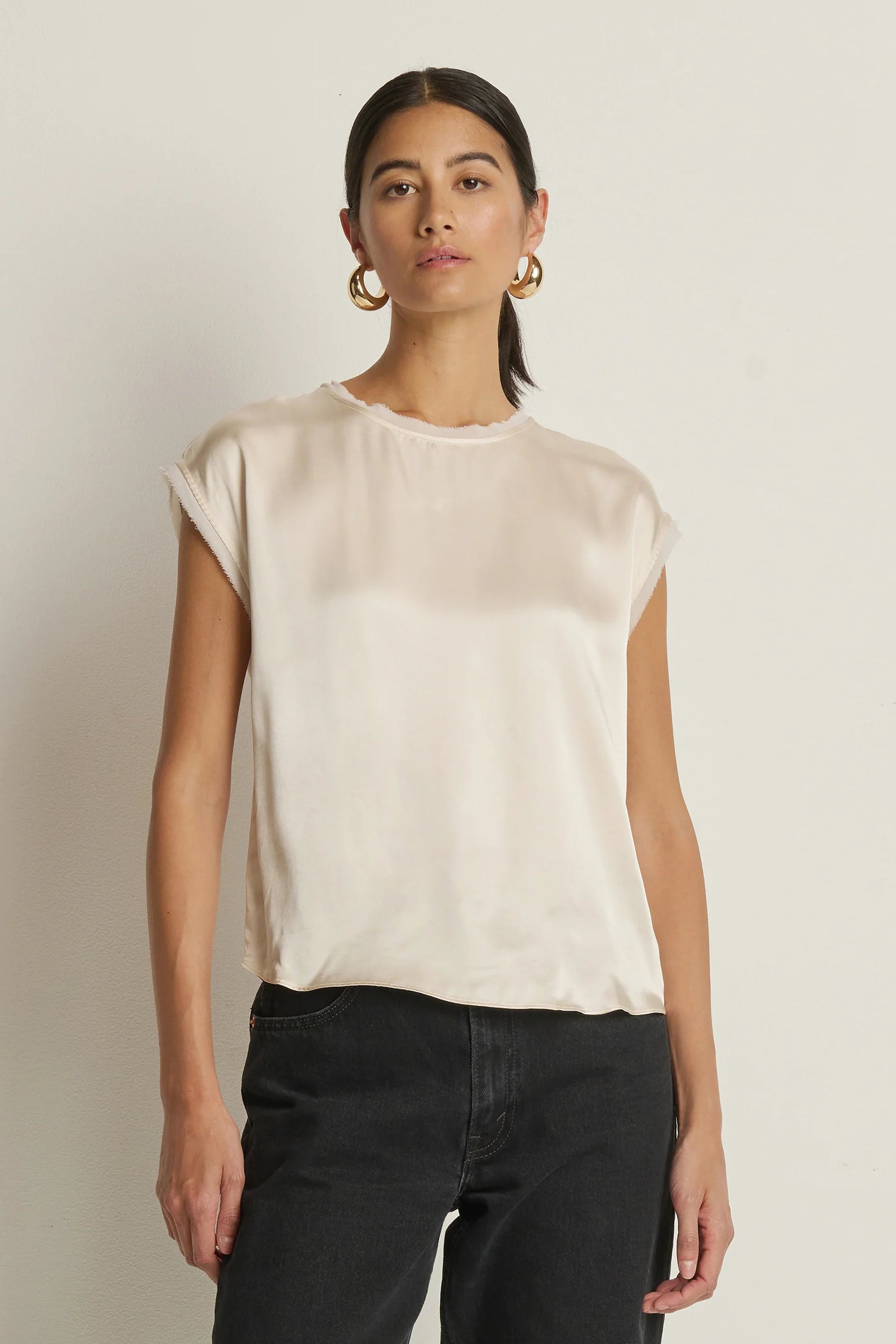 woman wearing a cream satin cap sleeved top