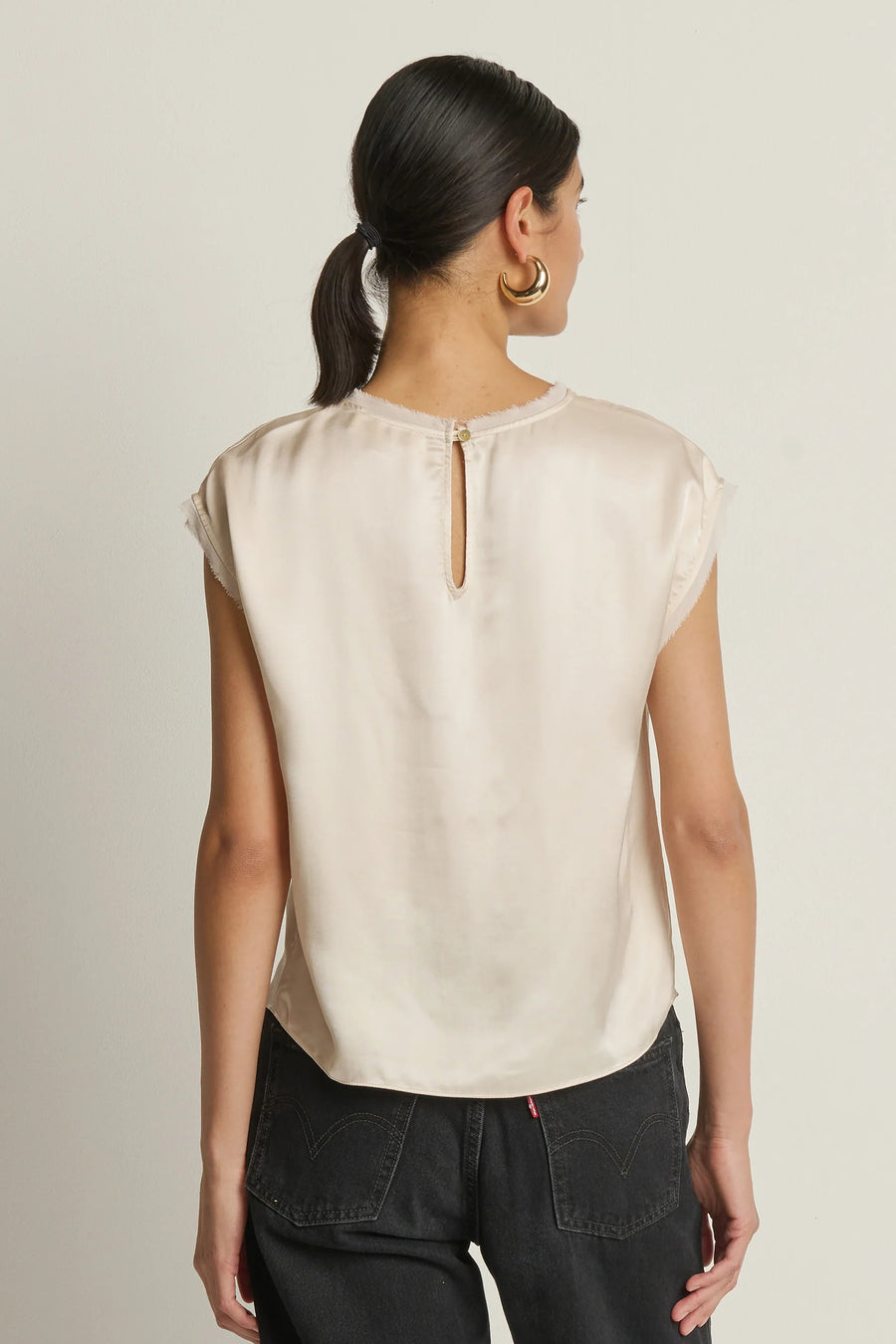 woman wearing a cream satin cap sleeved top