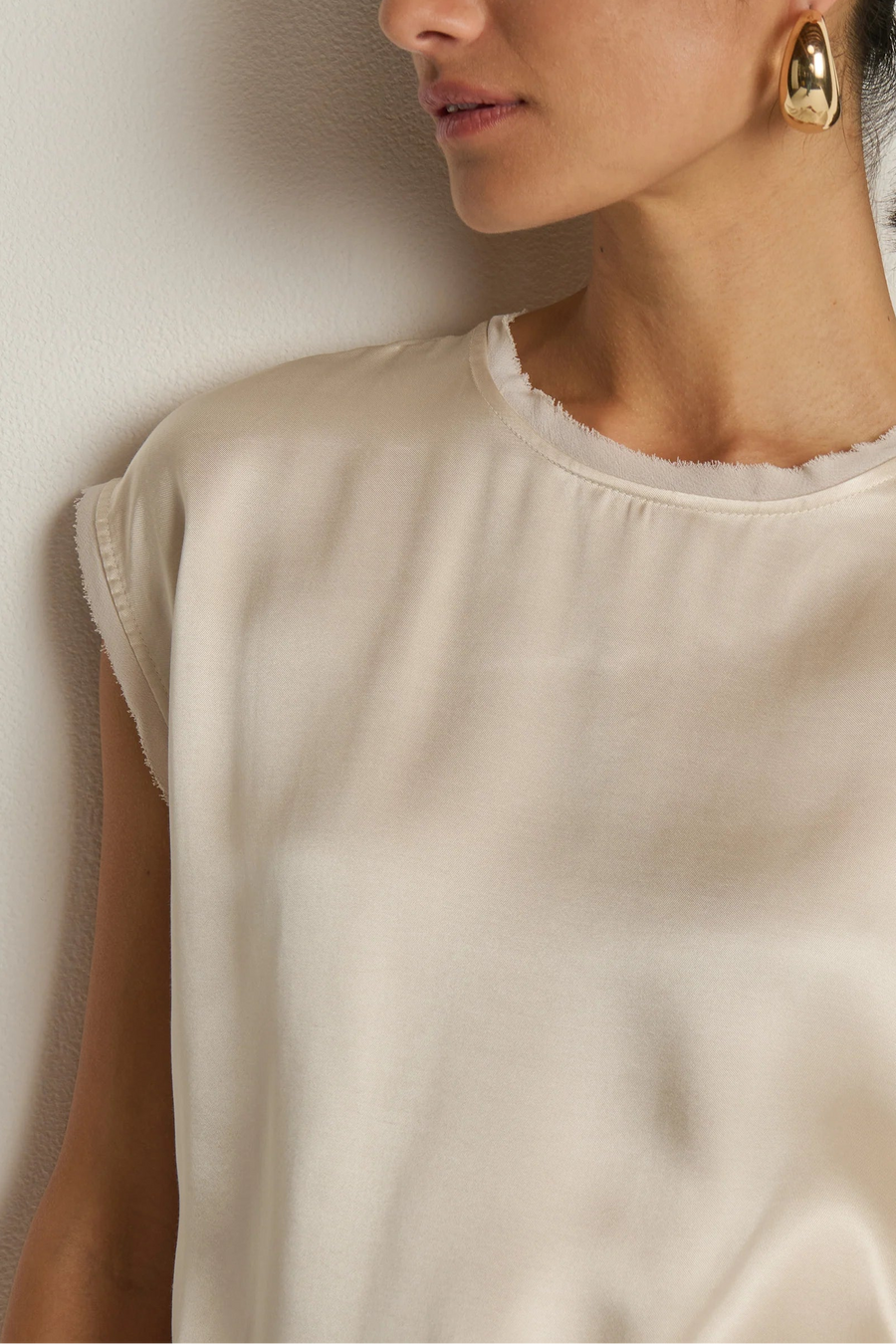 close-up of a cream satin cap sleeved top