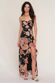 Woman wearing a floral strapless dress with a slit. 