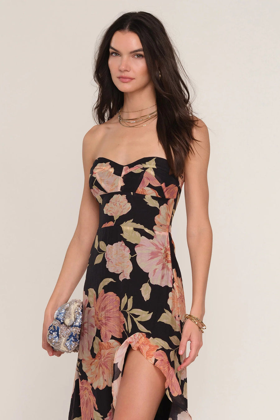 Woman wearing a floral strapless dress with a slit. 