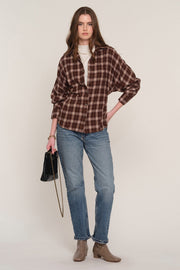 A woman modeling a brown and dark red plaid button-up shirt 