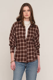 A woman modeling a brown and dark brown plaid button-up shirt over