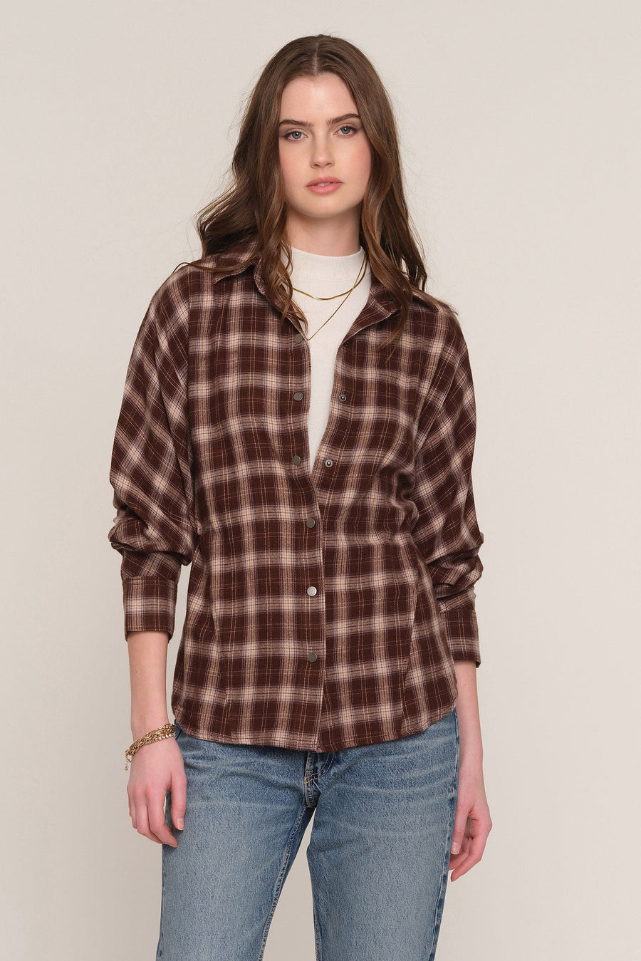 A woman modeling a brown and dark brown plaid button-up shirt over