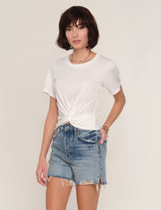 Woman wearing a white t-shirt with front twist detail. 