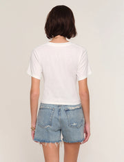 Woman wearing a white t-shirt with front twist detail. 