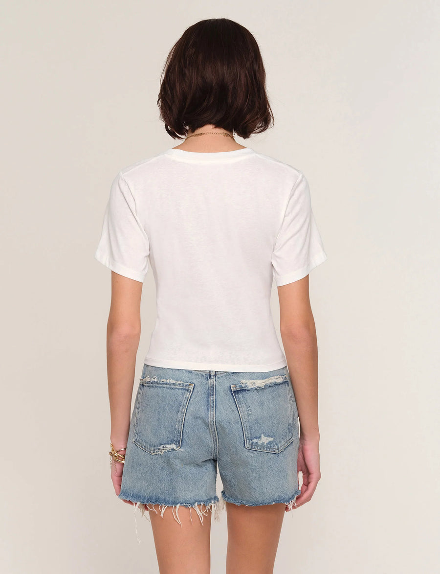 Woman wearing a white t-shirt with front twist detail. 