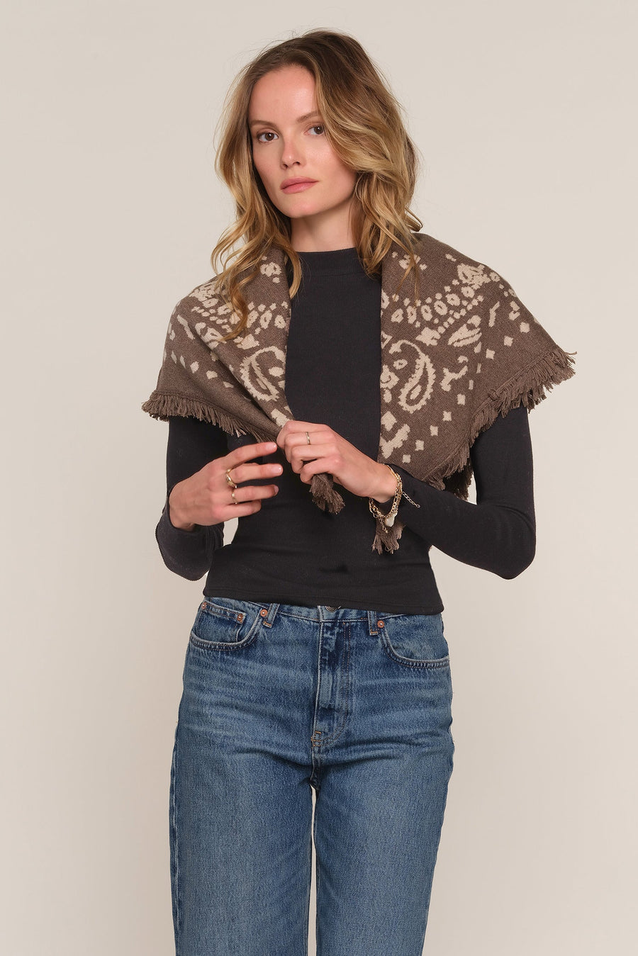 A woman modeling a brown and beige paisley patterned shawl draped over her shoulders