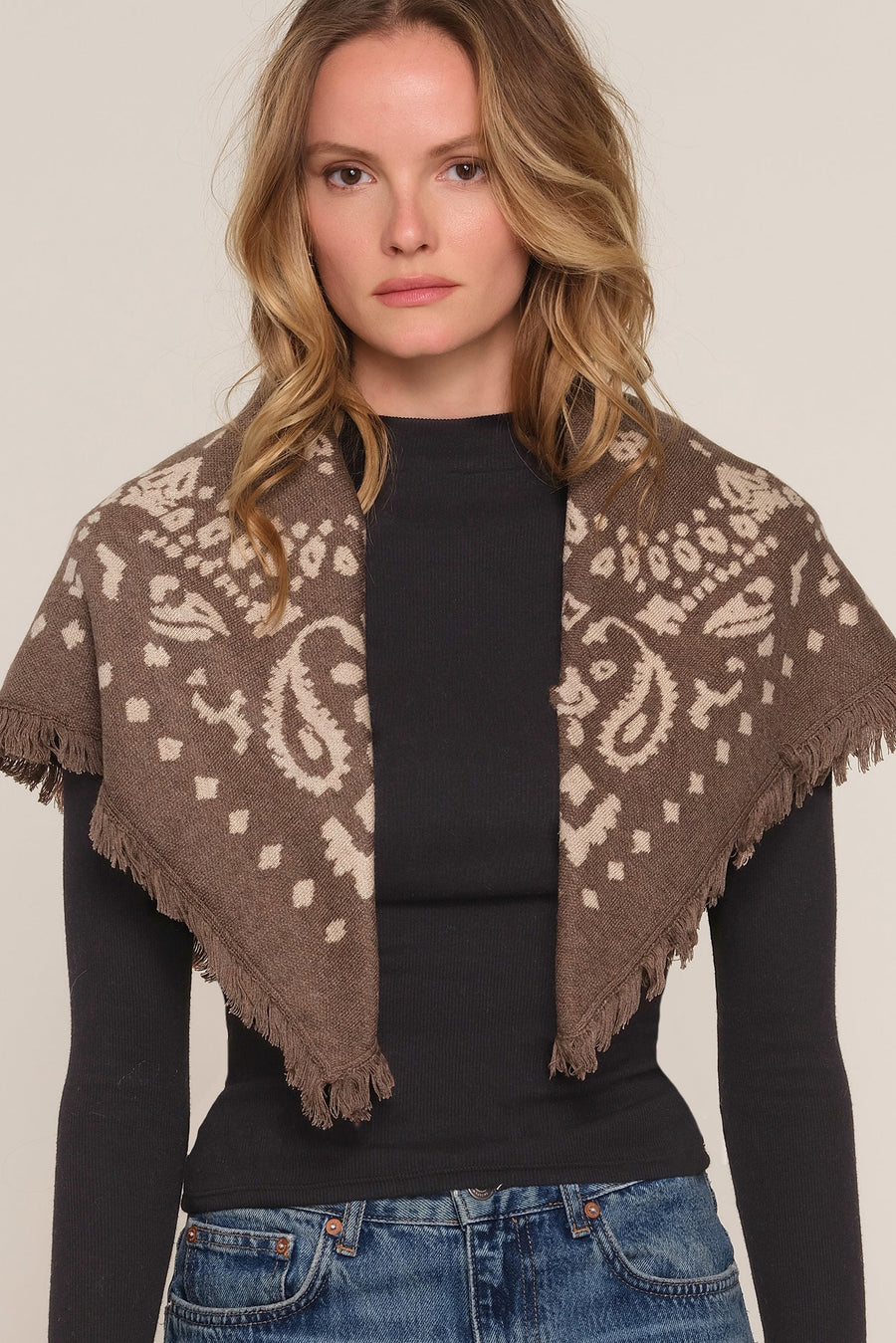 A woman wearing a brown and beige patterned knit shawl 