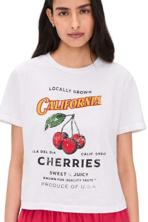 Woman wearing a white tee with a California cherries graphic on the front