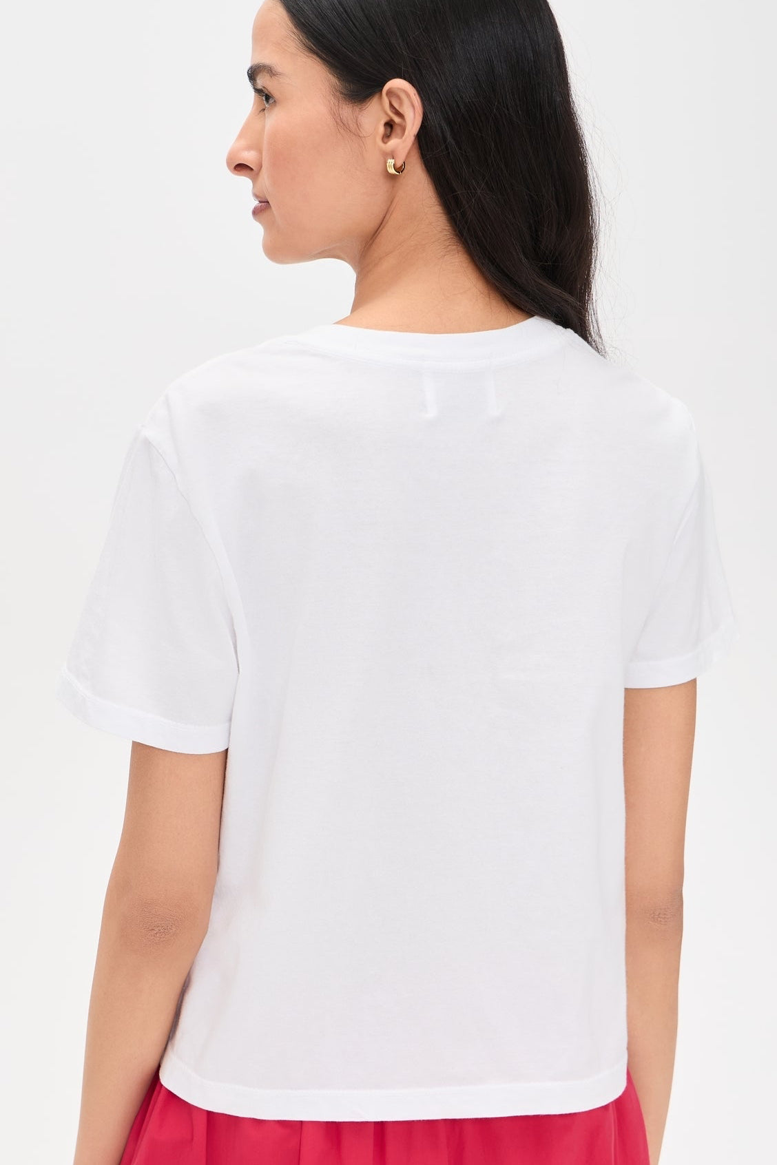 Back view of Woman wearing a white tee with a California cherries graphic on the front