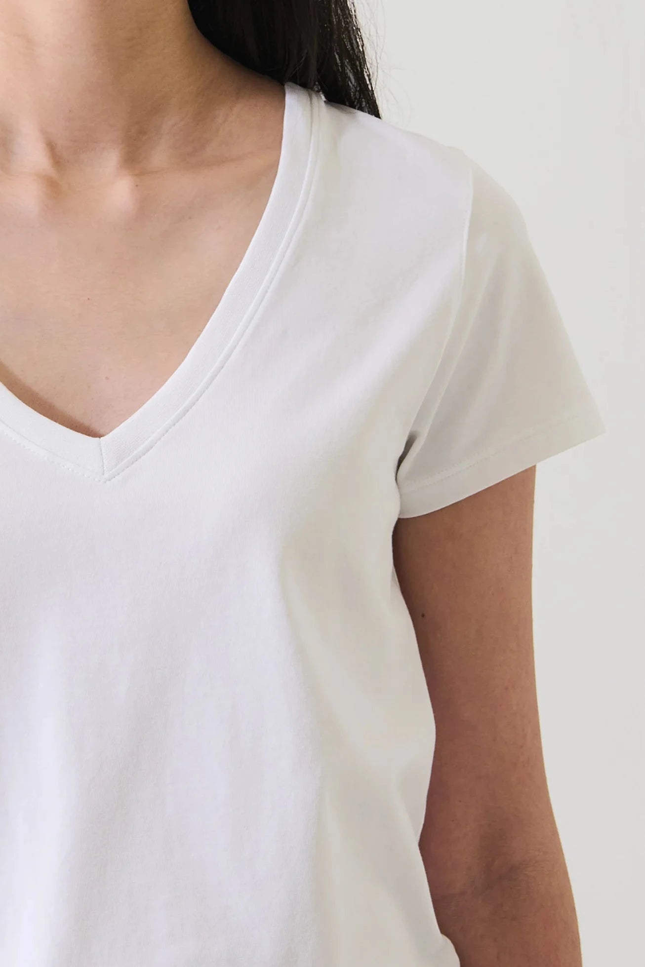 Close up of woman wearing a white v neck tee