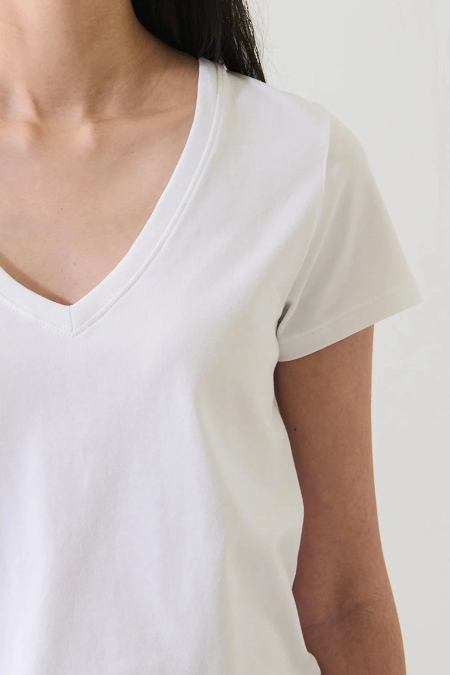 Close up of woman wearing a white v neck tee