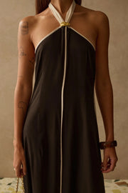 Close up of Woman wearing a halter neck dress in black with white trim 
