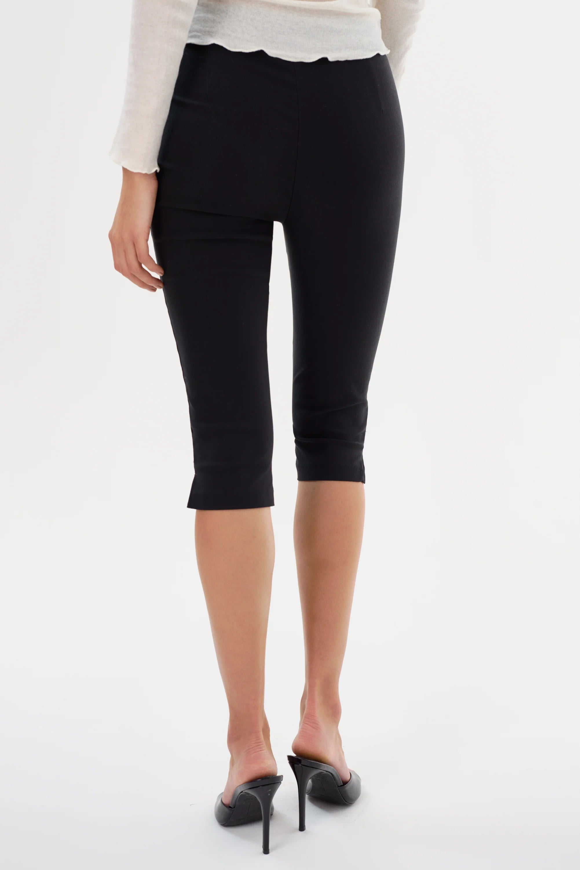 Back view of Woman wearing black slim capri shorts