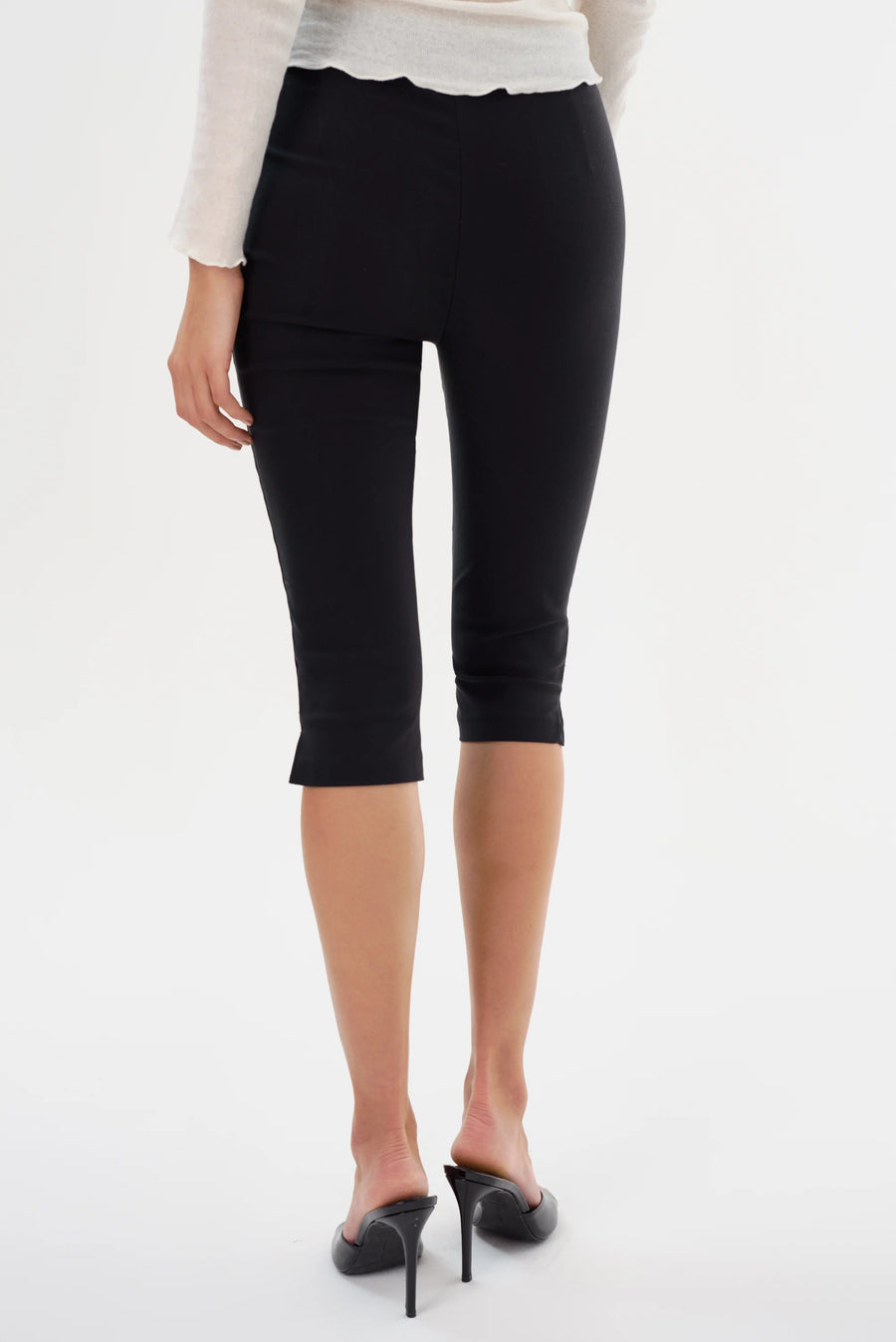 Back view of Woman wearing black slim capri shorts