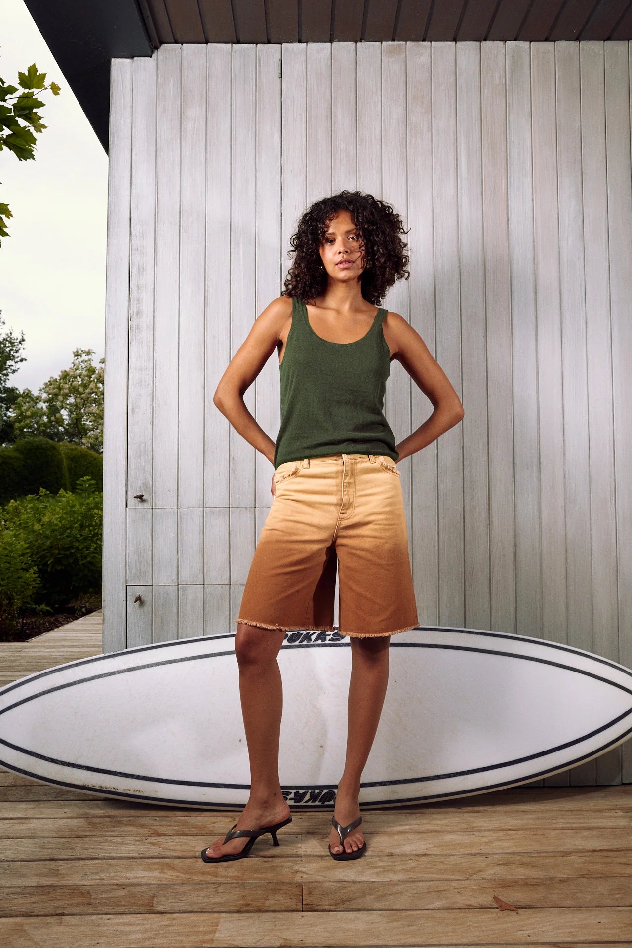 Woman wearing a dark green knit tank top